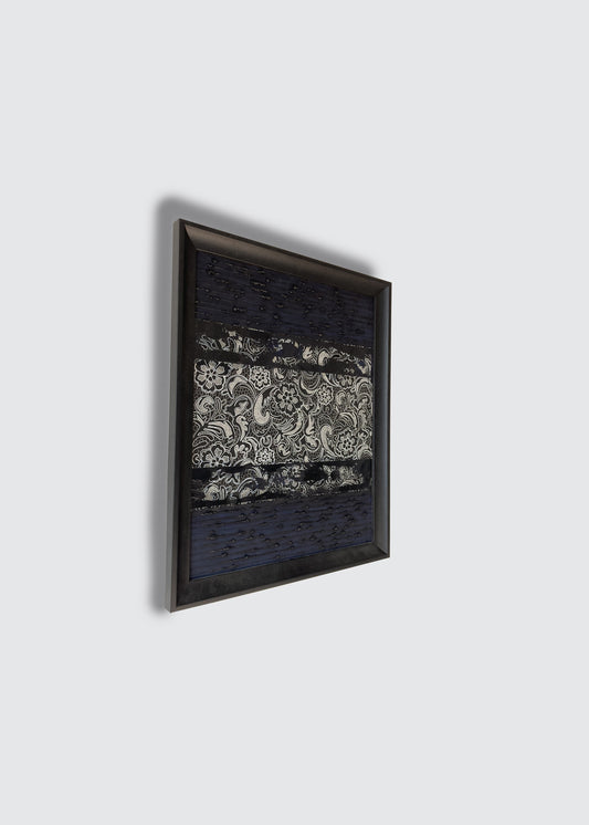 A framed wall art painting featuring a dark black and white abstract pattern with a central white ornate motif, shown hanging against a light gray wall.