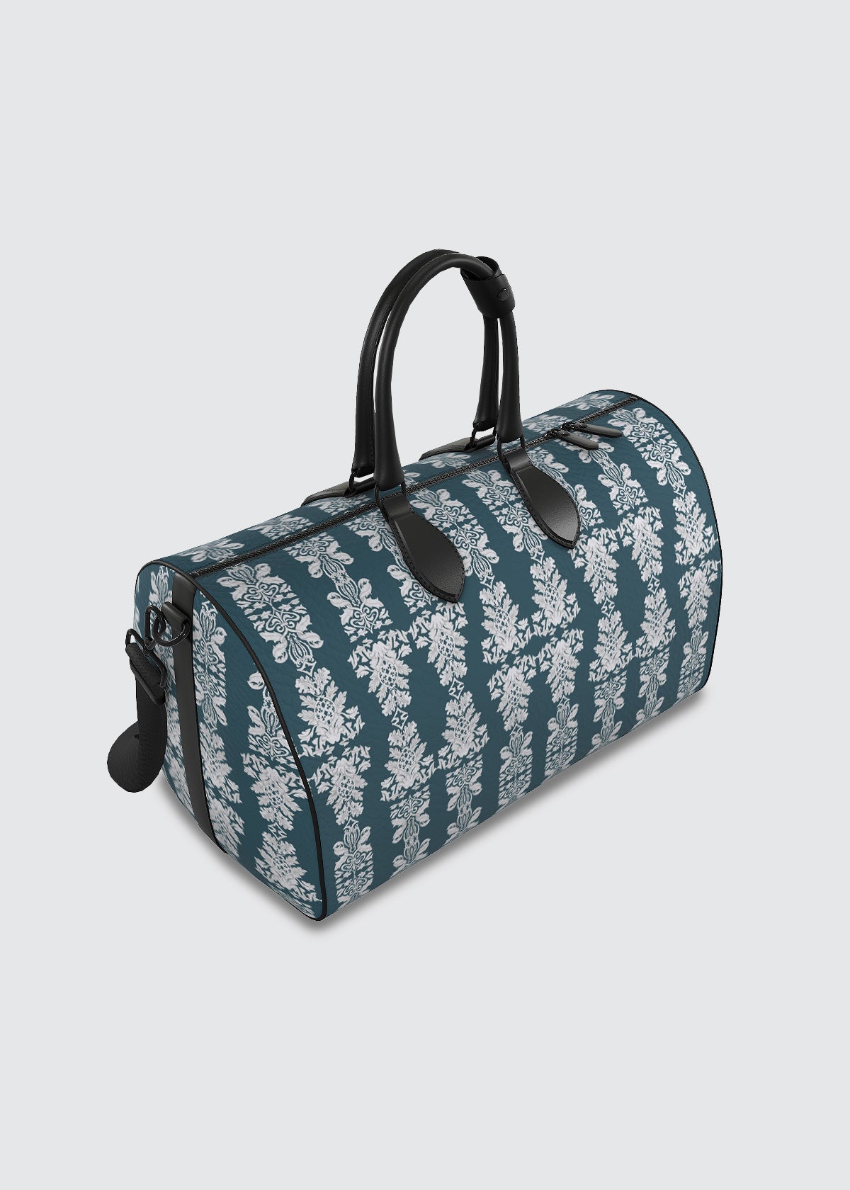 Teal blue duffle leather bag with floral pattern and black handles and strap.