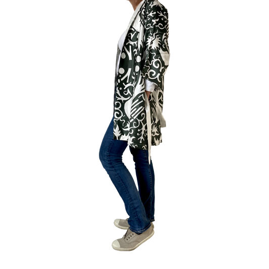 A green and white silk kimono with a phoenix pattern is shown on a model with jeans