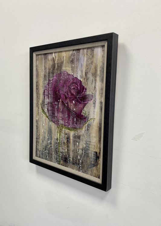 Framed wall art featuring a textured purple rose on a distressed beige and gray background, shown hanging on a white wall.