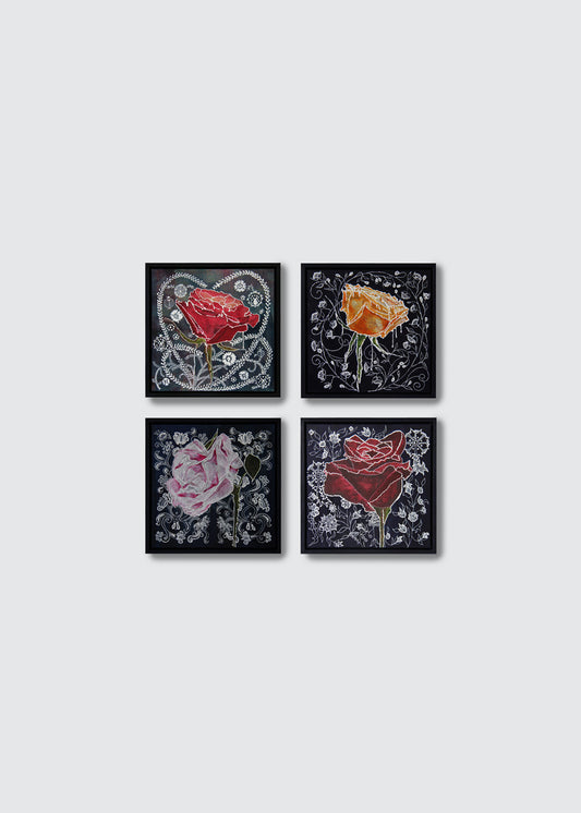 Four framed square art prints arranged in a 2x2 grid on a light gray background. Each print features a stylized rose on a dark background with ornate floral detailing: one red rose, one orange-yellow rose, one pink rose, and one dark red rose.
