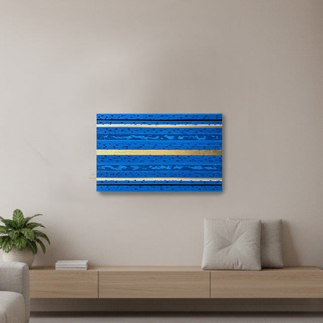A modern living room with a floating wood console. The focal point is a square blue abstract wall art piece with horizontal textured stripes mounted on the wall.