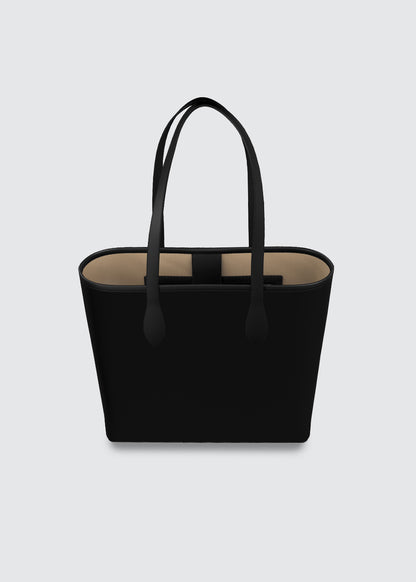 A black leather tote bag with long shoulder straps and a beige interior lining, shown against a light gray background.