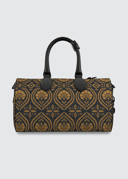 A structured duffel bag with a navy blue and ochre ornate patterned body, featuring dual black top handles and a black zipper closure, shown against a light gray background.