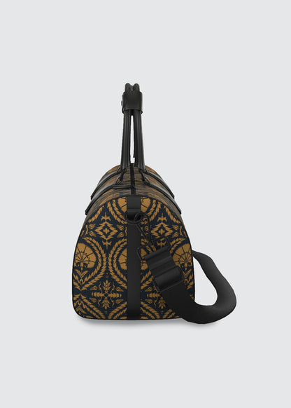 A small duffle bag featuring a Suzani pattern in black and sienna with black leather trim and a black shoulder strap, shown against a light gray background.