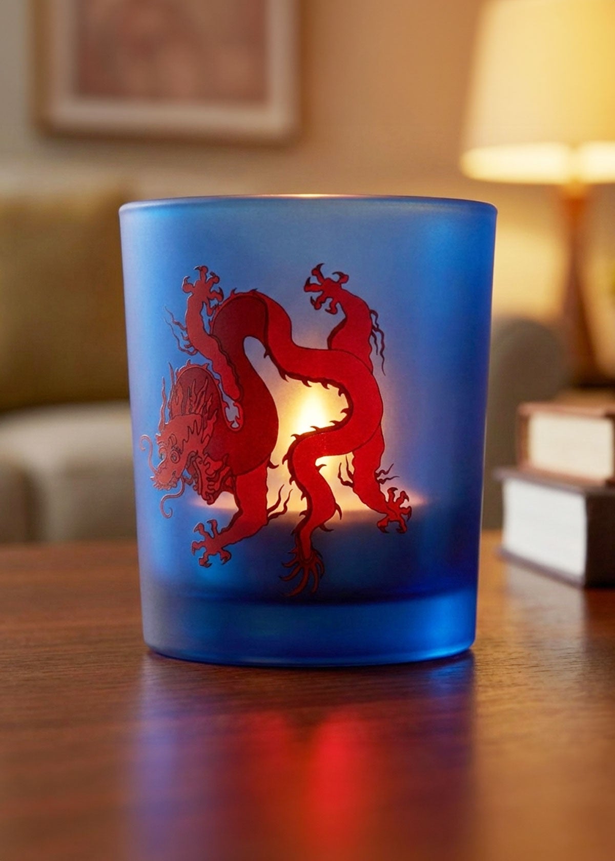 Blue glass candle holder with red dragon design.