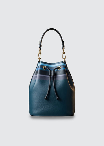 A dark teal leather bucket bag with a striped blue and purple drawstring top, black leather top handle, and gold-tone hardware.