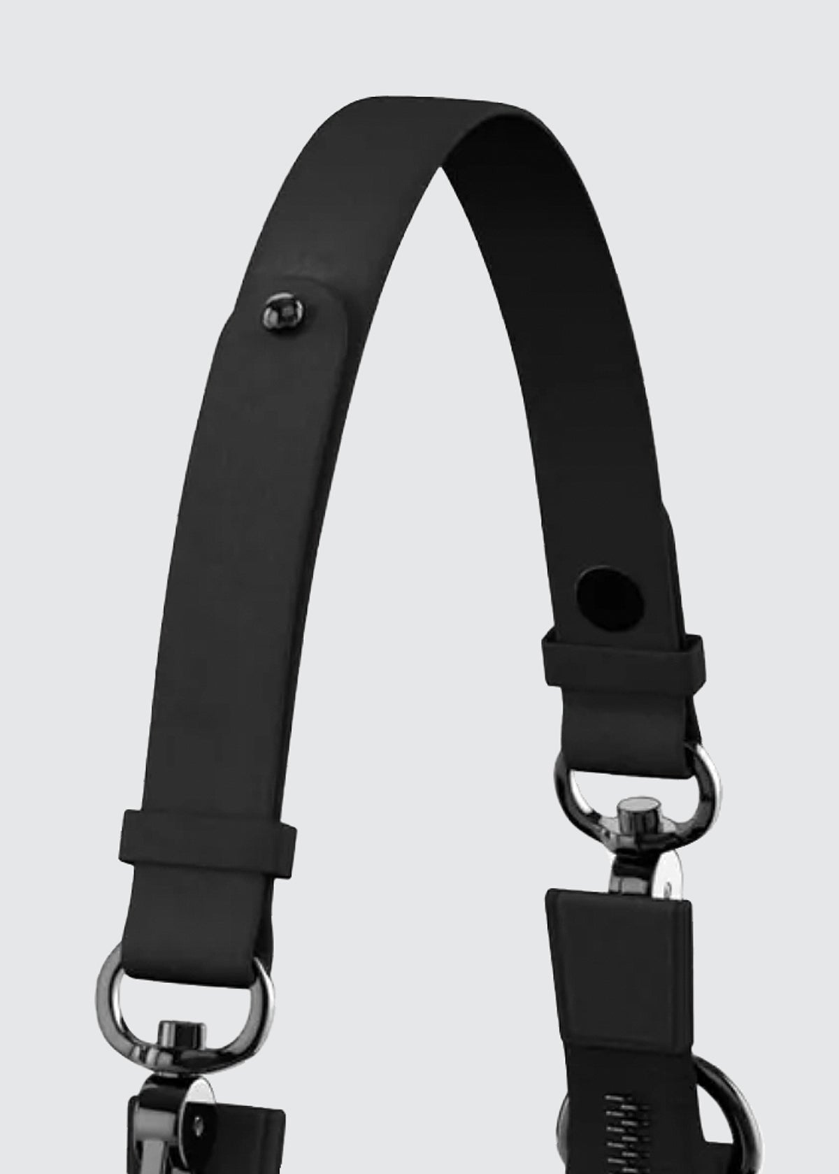 A close-up of a black leather shoulder strap with metal hardware, including D-rings and a snap hook clasp, set against a solid light gray background.