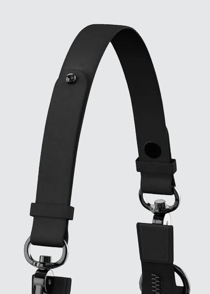 A close-up of a black leather shoulder strap with metal hardware, including D-rings and a snap hook clasp, set against a solid light gray background.