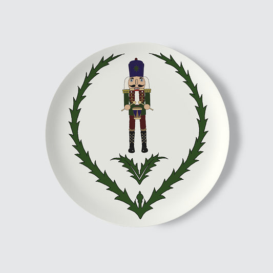 Decorative plate with a nutcracker and thistle design on a white background