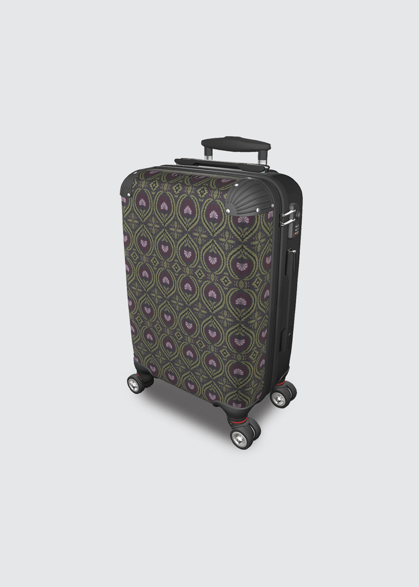 A hard-shell spinner suitcase with a dark green and purple geometric pattern, shown on a light gray background.