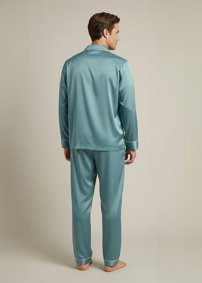 Man wearing teal silk pajamas shown frrom the back against a neutral background.