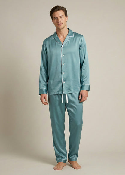 Man wearing teal silk pajamas against a plain background.