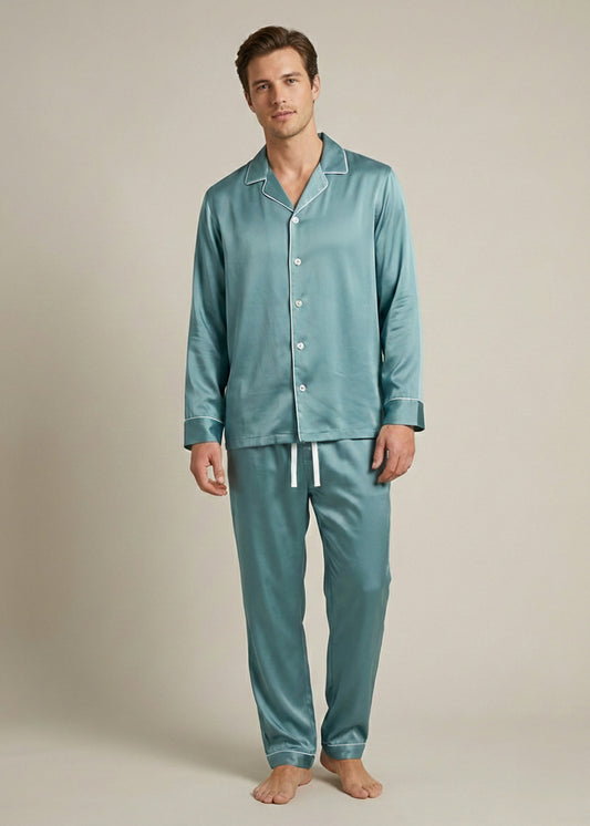 Man wearing teal silk pajamas against a plain background.