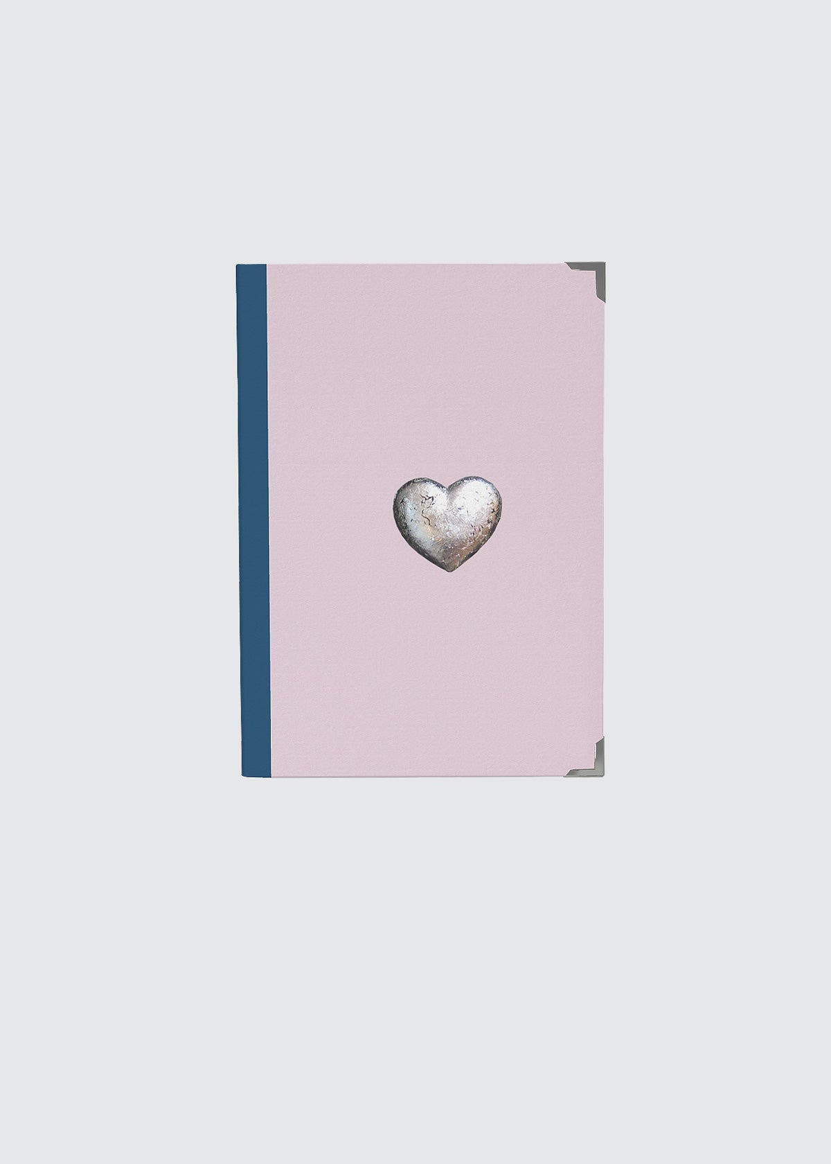 Pink hardback notebook journal with a heart-shaped silver emblem.