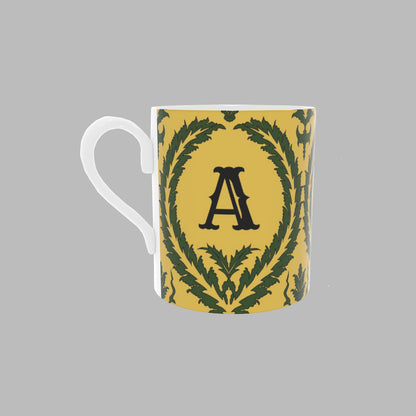 Yellow bone china Mug with green wreath pattern and the initial 'A'.