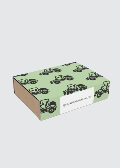Green gift box with black car pattern and a visible brand label on a white background.