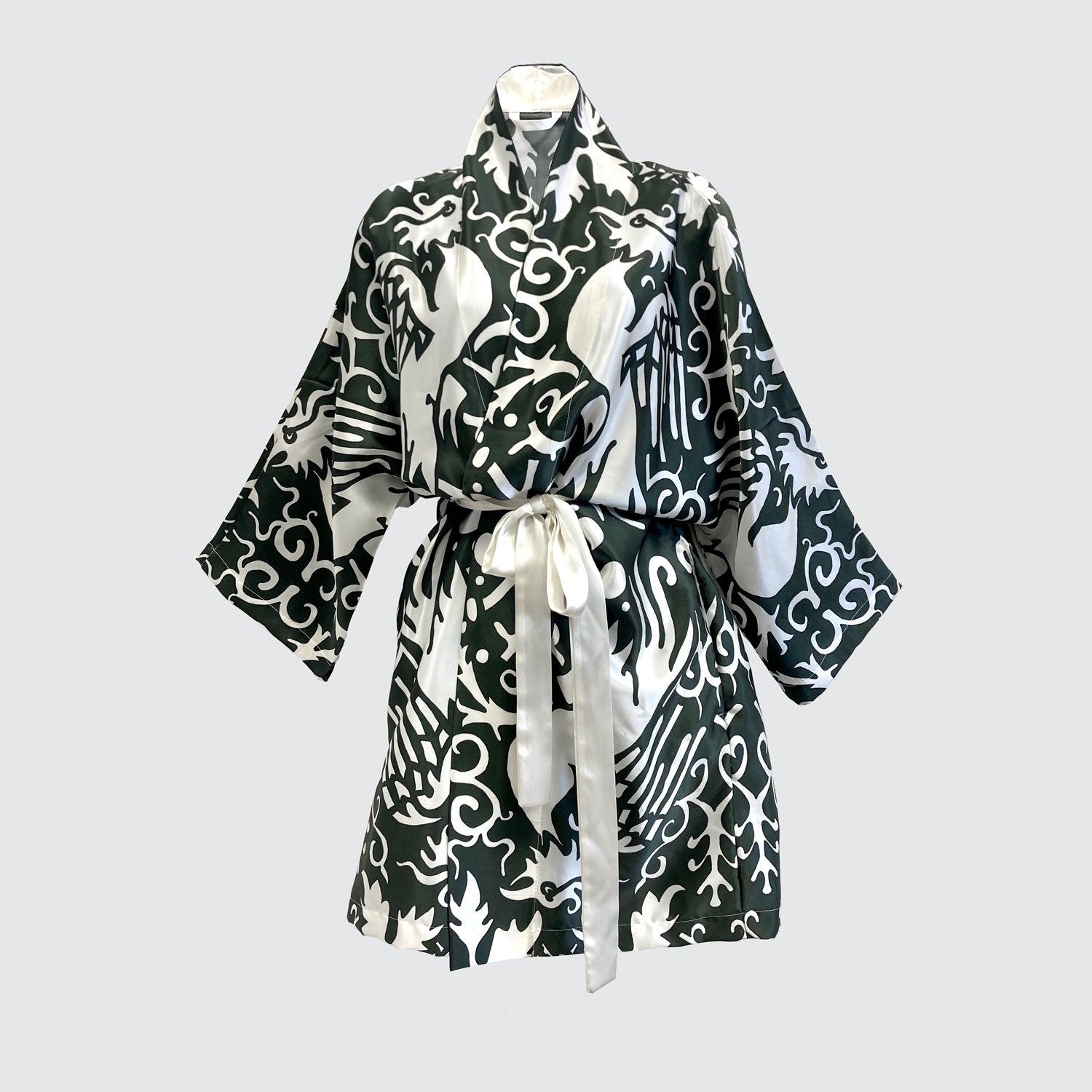A silk kimono with a white phoenix pattern on a green background.